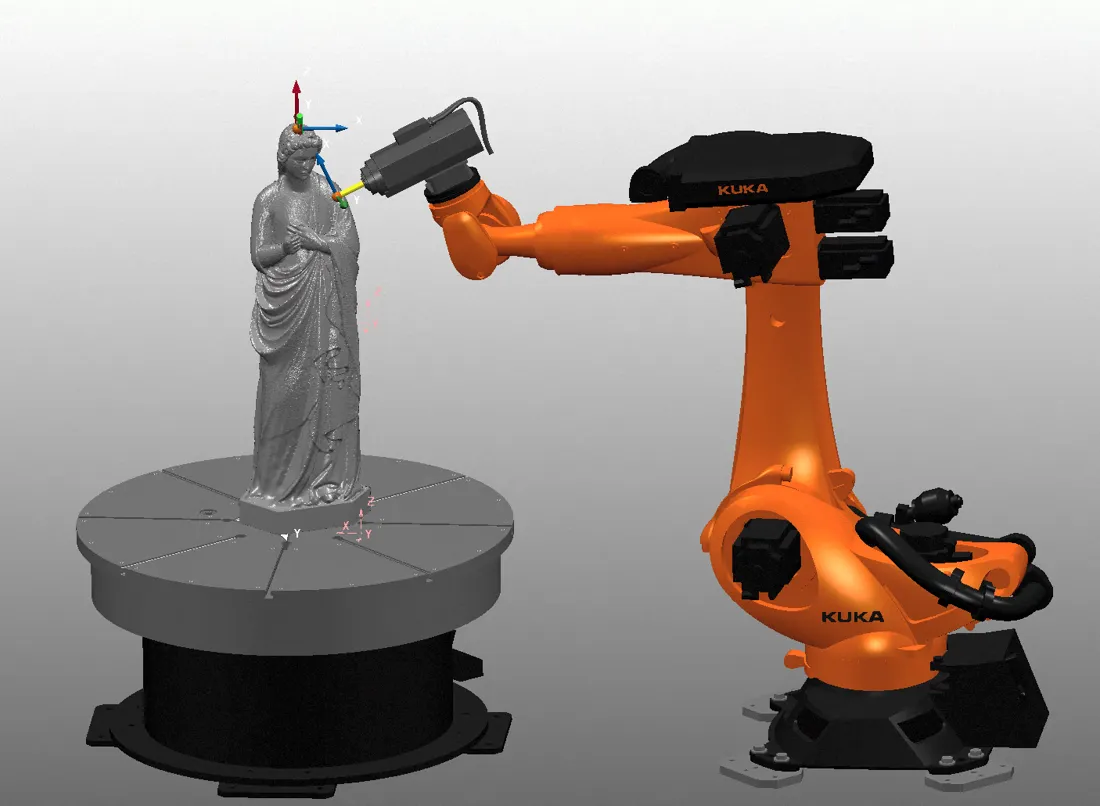 Simulation d'usinage : un bras robotisé orange taille une statue drapée posée sur un plateau tournant.
